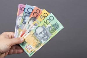 australiano dinheiro dentro a mão em uma cinzento fundo foto