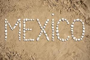 México - palavra fez com pedras em areia foto