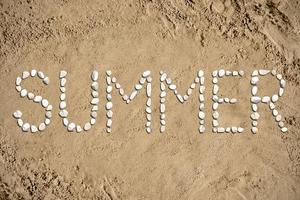 verão - palavra fez com pedras em areia foto