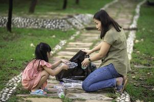 mãe e filha asiáticas ajudam o ambiente de caridade de coleta de lixo. foto