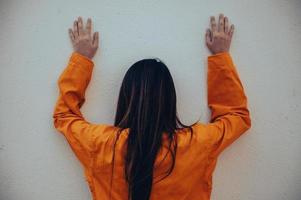 prisioneiro no conceito de manto laranja, retrato de mulher asiática em uniformes de prisão em fundo branco, foto