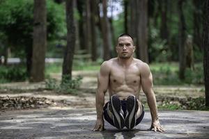 bonito homem exercícios de suspensão em uma Barra ar livre, ásia homem trens para esportivo eventos foto