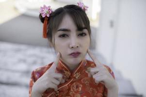 retrato linda mulher asiática em vestido cheongsam, povo da tailândia, conceito de feliz ano novo chinês, feliz senhora asiática em vestido tradicional chinês foto