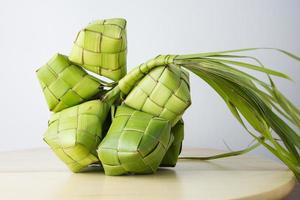 ketupat Lebaran é uma típica indonésio Comida durante a festivo estação do ketupat, eid al fitr, eid al adha, natural arroz embrulho fez a partir de jovem coco folhas em uma branco fundo, esvaziar espaço foto