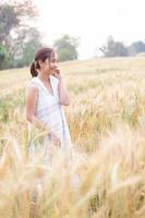 jovem ásia mulheres dentro branco vestidos dentro a cevada arroz campo foto