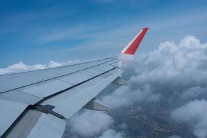 avião asa vôo acima a céu com branco nuvens. Visão a partir de aeronave janela. vôo e viajando conceito. foto