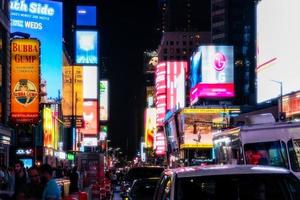 Novo Iorque cidade, EUA - agosto 9, 2019-pessoas e turistas passear entre a luzes e arranha-céus do Tempo quadrado dentro Manhattan durante uma verão noite foto