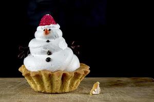 boneco de neve Bolinho. Natal bolo em uma Preto fundo. foto