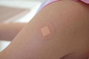 menina asiática vacinada com esparadrapo após injeção de vacina foto
