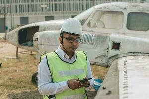 aeronave mecânico examinando avião asa foto