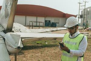 aeronave mecânico examinando avião asa foto