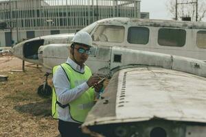 aeronave mecânico examinando avião asa foto