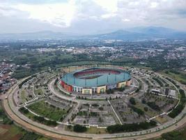 bogor, indonésia 2021 - vista aérea do maior estádio estádio pakansari de drone com nuvens e pôr do sol foto