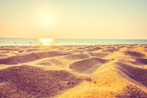 lindo mar e areia com pôr do sol foto