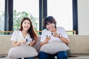 casal jogando vídeo jogos juntos dentro vivo sala, felicidade e casado pessoas conceito. foto