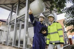 Os engenheiros trabalham no local para manter o hélio líquido, a verificação do cronograma de manutenção preventiva, o pessoal da tailândia, os técnicos e os engenheiros discutem o trabalho juntos. foto