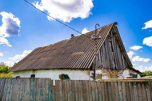 linda e velha casa de fazenda abandonada na zona rural em fundo natural foto