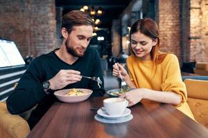 homem e mulher sentado dentro uma cafeteria comunicação lanche estilo de vida romance foto