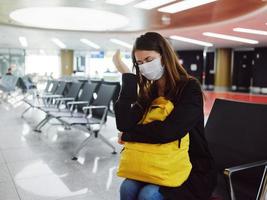 mulher com fechadas olhos médico mascarar esperando passageiro com bagagem foto