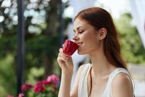 jovem à moda mulher segurando uma café copo em pé dentro a parque às verão relaxamento conceito foto