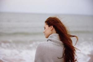 bonita mulher com grandes cabelo em a de praia natureza panorama andar relaxamento conceito foto