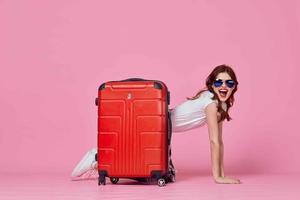 mulher turista vermelho mala de viagem Passaporte e avião bilhetes Rosa fundo foto