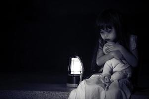 triste criança fantasma às noite, dia das bruxas festival conceito, sexta-feira 13º, terror filme cena, uma menina com boneca foto