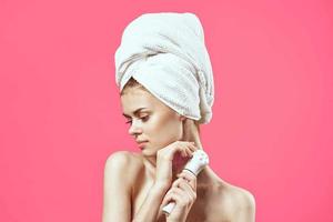 mulher com nu ombros e cosmetologia limpar \ limpo pele relaxamento Rosa fundo foto