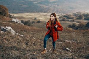 mulher caminhante dentro Jaqueta chuteiras com mochila viagem dentro montanhas panorama foto