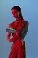 jovem mulher glamour posando vermelho luz metal armaduras em mão estilo de vida inalterado foto