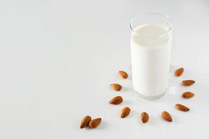 um copo de leite de amêndoa em um fundo branco