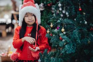 retrato do pequeno menina dentro Natal festival, asiático criança inverno feriado foto