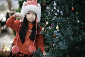 retrato do pequeno menina dentro Natal festival, asiático criança inverno feriado foto