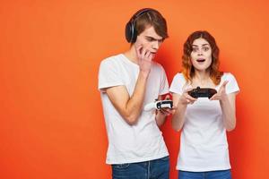 uma homem e uma mulher dentro branco Camisetas segurando telefones comunicação entretenimento foto