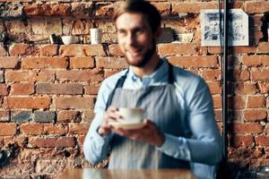 masculino garçom avental café copo tijolo parede restaurante serviço foto