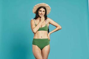 bonita mulher dentro verde roupa de banho de praia chapéu posando moda foto