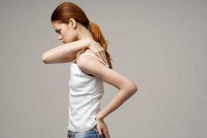 mulher dentro branco camiseta dor dentro a pescoço artrite crônica doença estúdio tratamento foto
