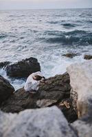 mulher dentro branco vestir pedras natureza panorama oceano viagem inalterado foto