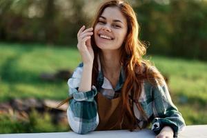 uma mulher rindo e sorridente dentro natureza dentro uma verde parque foto