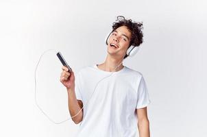 cabelo encaracolado cara dentro fones de ouvido com uma telefone dentro dele mãos música tecnologia foto