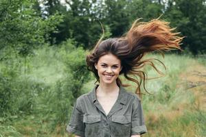 mulher com solto cabelo corre em uma Prado dentro a floresta foto