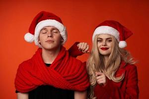 homem e mulher dentro Novo anos roupas Natal feriado vermelho fundo foto