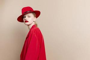 retrato do uma mulher vermelho Jaqueta e chapéu vermelho lábios moda isolado fundo foto