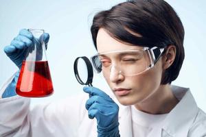 mulher cientista olhando através uma ampliação vidro às uma químico solução trabalhos biotecnologia foto