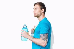 esporte homem com tatuagem em dele braço exercite-se água garrafa cortada Visão luz fundo foto