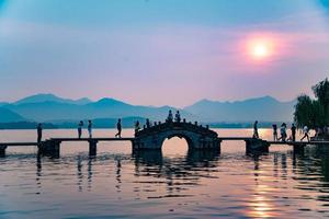 lindo Hangzhou dentro pôr do sol, antigo pavilhão silhueta em a oeste lago, china foto