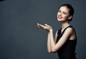 atraente mulher gesticulando com dela mãos em uma cinzento fundo cópia de espaço modelo foto
