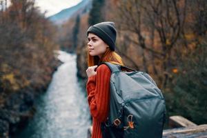 mulher turista mochila rio montanhas outono foto