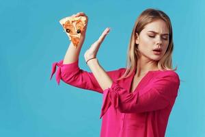 mulher dentro Rosa camisa pizza segurando velozes Comida dieta azul fundo foto