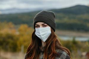 retrato do uma mulher dentro uma médico mascarar em uma fundo do a outono floresta dentro natureza foto